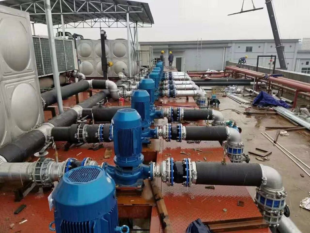 Flexible rubber joints installed across multiple pump lines in a water piping system