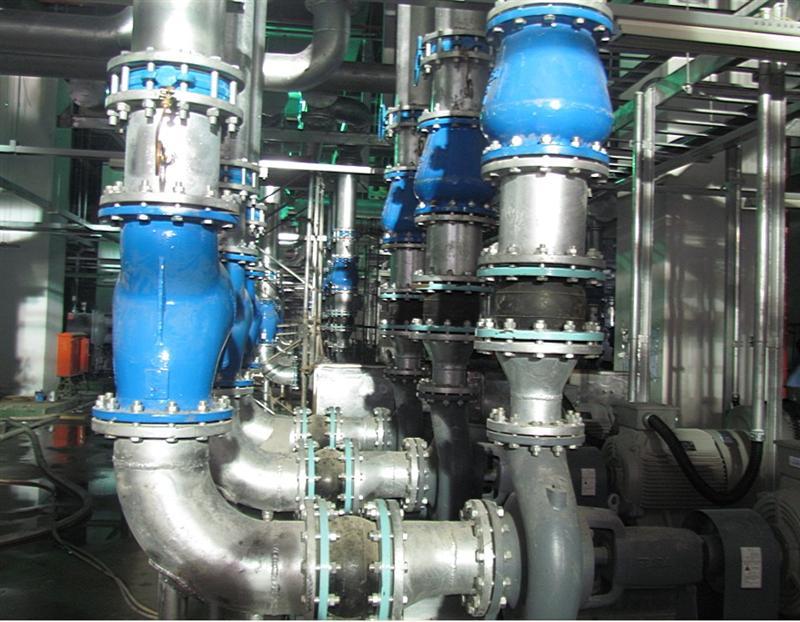 Rubber expansion joint installed beside valves and pump equipment in industrial piping